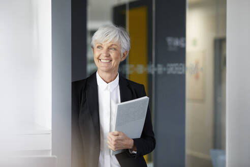 Portrait of smiling senior businesswoman looking at distance - RBF07583