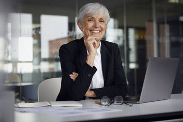 Portrait of relaxed senior businesswoman at desk in her office - RBF07614