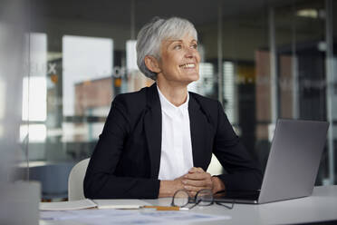 Senior businesswoman at desk in her office - RBF07615