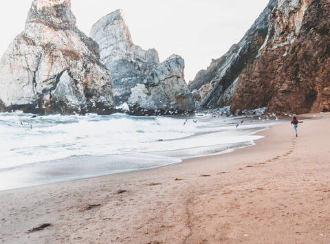 Young woman running at Praia da Ursa, Lisboa, Portugal stock photo