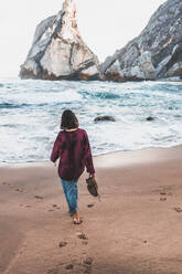 Rückansicht einer jungen Frau beim Spaziergang am Praia da Ursa, Lisboa, Portugal - FVSF00195