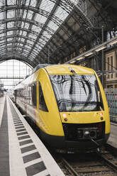 Germany, Hesse, Frankfurt, Yellow train waiting at train station - AHSF02307