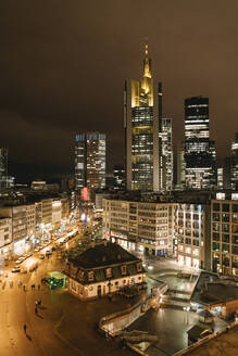 Deutschland, Hessen, Frankfurt, Beleuchteter Stadtplatz bei Nacht mit Wolkenkratzern in der Innenstadt im Hintergrund - AHSF02337