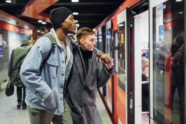 Junges Paar auf dem Bahnsteig beim Einstieg in die U-Bahn - MEUF00512