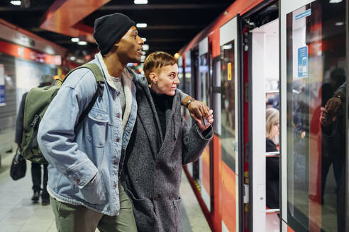 Young couple at the station platform entering subway - MEUF00512