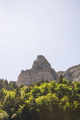 Spanien, Provinz Huesca, Klarer Himmel über grünem Wald am Fuße eines hohen Berges - FVSF00214