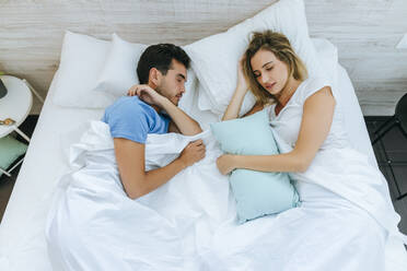 High angle view of couple sleeping on bed in bedroom at home - KIJF02991