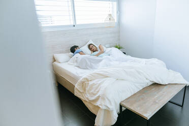 Ehepaar schläft auf einem Bett im Schlafzimmer zu Hause - KIJF02993