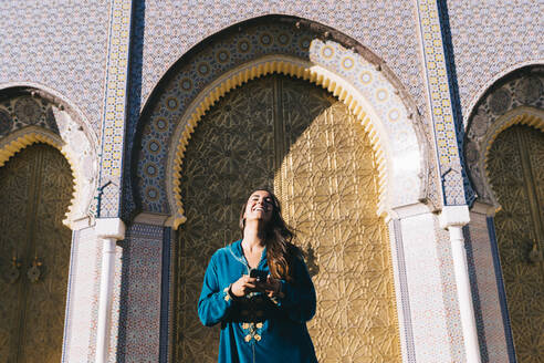 Junge Frau vor traditioneller Architektur mit marokkanischem Gewand, Marokko - DAMF00402