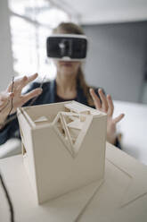 Woman with architectural model wearing VR glasses - GUSF03510