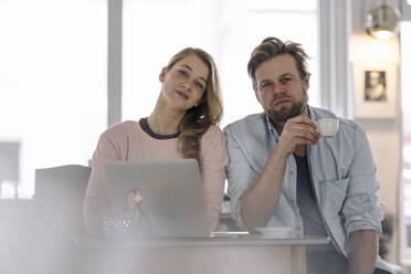 Portrait of young woman with laptop and man in a cafe - GUSF03533