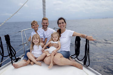 Family sitting on deck during sailing trip - GMLF00104