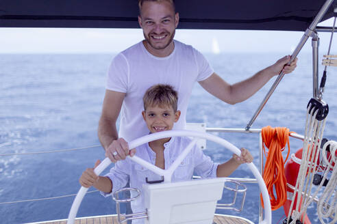 Vater und Sohn steuern ein Segelboot - GMLF00105