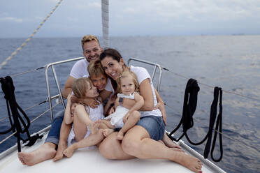 Family sitting on deck during sailing trip - GMLF00106