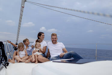 Family sitting on deck during sailing trip - GMLF00107