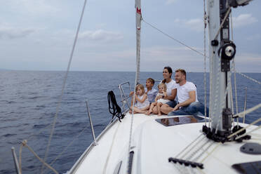 Family sitting on deck during sailing trip - GMLF00108