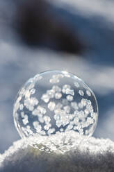 Close up image of soap bubble freezing in the snow on a winter's day. - CAVF79332