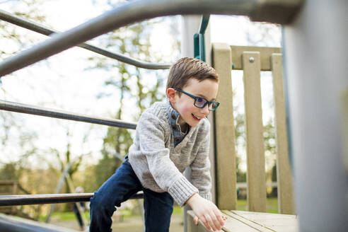 Kleiner Junge klettert auf Spielplatzgeräten. - CAVF79369