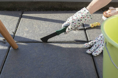 Germany, Hands of woman wearing protective gloves working on balcony - CHPF00674