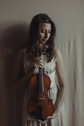 Frau hält Geige und schaut nach unten - GMLF00113