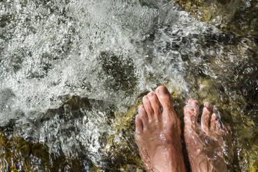 Man's feet on stone in a brook - WFF00347