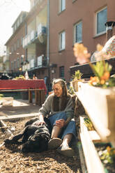Glückliche junge Frau mit Hund im Garten - GUSF03567