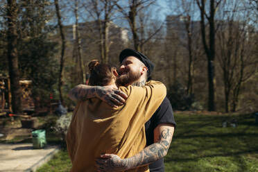 Happy couple hugging in garden - GUSF03676