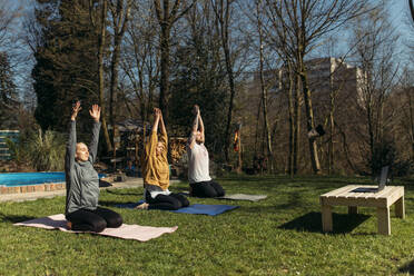 Gruppe von Freunden mit Laptop beim gemeinsamen Workout im Garten - GUSF03679