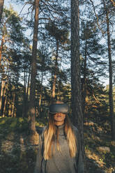 Junge Frau mit VR-Brille in der Natur - GUSF03765