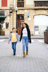 Happy mother walking hand in hand on the street with her son - DGOF00905