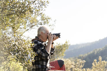 Älterer Mann beim Fotografieren in der Natur - AFVF06127