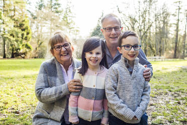 Großeltern posieren für ein Foto mit ihren Enkelkindern. - CAVF79461