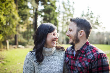 Attractive young couple sharing a laugh outdoors. - CAVF79471