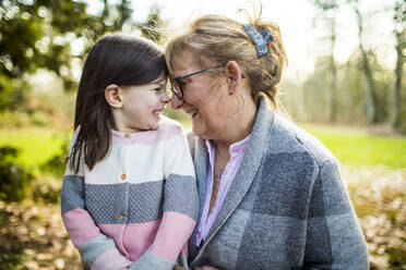 Cute girl smiling at grandma in outdoor setting. - CAVF79485