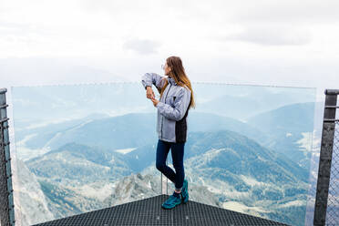 Junges Mädchen genießt die Aussicht auf die Alpen von der Aussichtsplattform - CAVF79538