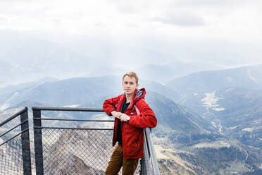 Millennial-Mann genießt Bergblick auf die Alpen von der Aussichtsplattform - CAVF79544