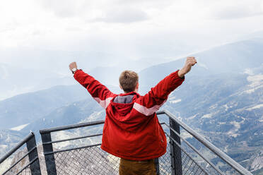 Millennial-Mann genießt Bergblick auf die Alpen von der Aussichtsplattform - CAVF79548