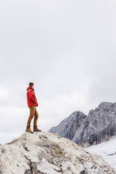 Ein junger Mann aus der Jahrtausendwende genießt die Aussicht auf die Alpen auf einem Gletscher - CAVF79556