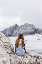 Young millennial girl enjoys the views of the Alps standing on glacier - CAVF79559