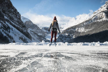 Frau beim Schlittschuhlaufen auf dem zugefrorenen See am Lake Louse im Banff National Park - CAVF79573
