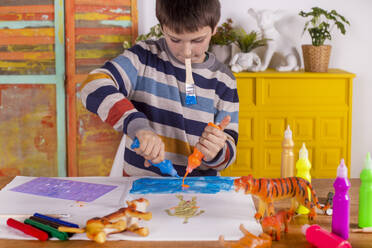 Boy creating artwork at home. - CAVF79603