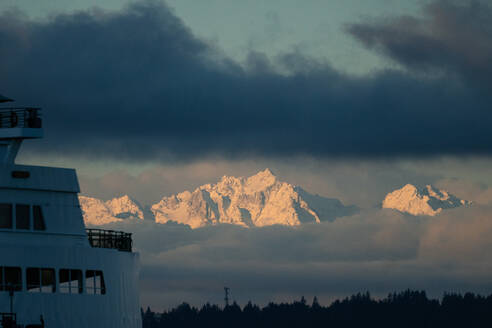 Die Olympic Mountain-Kette durch die Wolken bei Sonnenaufgang von Seattle aus - CAVF79629