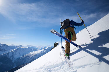 Ski tourer doing an uphill kick turn with mountain backdrop - CAVF79682