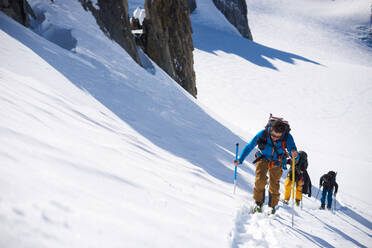 Gruppe von 3 Personen beim Skitourengehen am Berg - CAVF79692