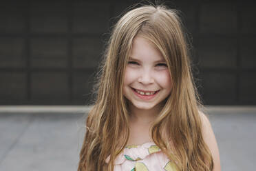 Closeup of a young girl in front of a garage door - CAVF79697