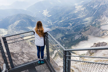 Junges Mädchen genießt die Aussicht auf die Alpen von der Aussichtsplattform - CAVF79756