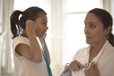 General Practitioner using a stethoscope during check-up a young girl - CAVF79758