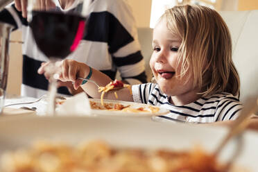 Porträt eines glücklichen kleinen Mädchens, das Spaghetti isst - WFF00370