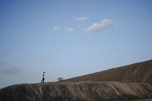 Mature businessman walking on a disused mine tip - JOSEF00367