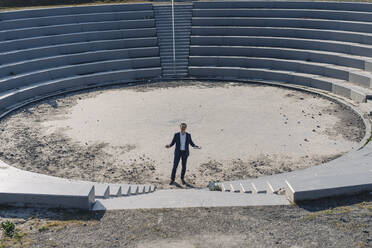 Älterer Geschäftsmann in einem Amphitheater auf einer stillgelegten Bergwerkshalde - JOSEF00395